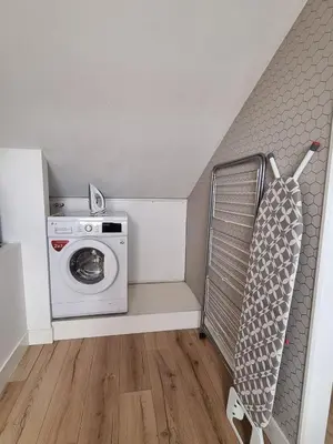 a laundry room with a washing machine and a washer at Prachtige, lichte condo met balkon in Bergen