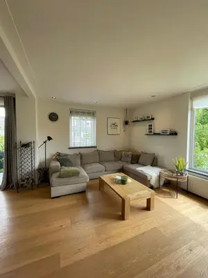 a living room with a couch and a coffee table at Prachtige, lichte condo met balkon in Bergen