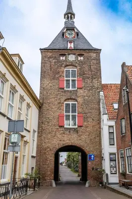 a large brick building with a clock tower on top at Huize de Lekpoort - The City View - Historic Apartment in Vianen Center in Vianen