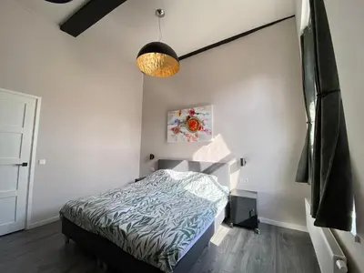 a bedroom with a bed and a ceiling at Huize de Lekpoort - The City View - Historic Apartment in Vianen Center in Vianen