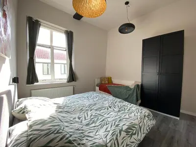 a bedroom with a bed and a window at Huize de Lekpoort - The City View - Historic Apartment in Vianen Center in Vianen