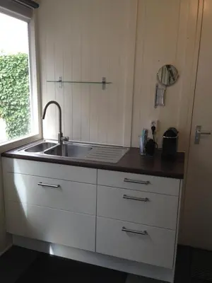 a kitchen counter with a sink and a window at Tiny House Madame Jeanette nabij centrum en zee in Zandvoort