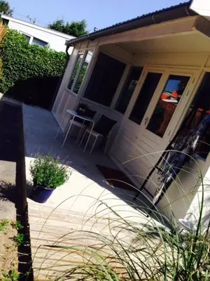 a porch of a house with a table and a chair at Tiny House Madame Jeanette nabij centrum en zee in Zandvoort