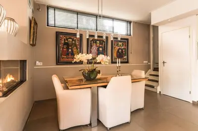a dining room with a table and chairs and a fireplace at Executive Houseboat-Apartment Sumatra in Amsterdam