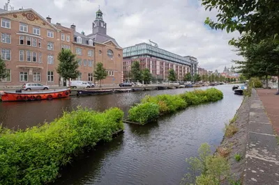 a river in the middle of a city with buildings at Charming Apartment in City Centre in Amsterdam