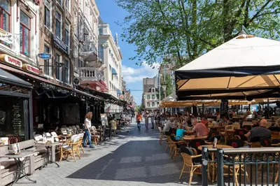 a street with tables and chairs and people sitting at tables at Charming Apartment in City Centre in Amsterdam