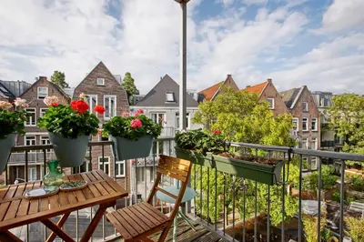 a balcony with a table and chairs and flowers at Charming Apartment in City Centre in Amsterdam