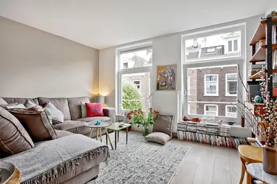 a living room with a couch and two windows at Charming Apartment in City Centre in Amsterdam