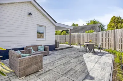 a patio with a table and chairs and a fence at Cosy Nest in Noordwijk aan Zee
