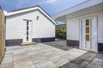 a white house with a patio in front of it at Cosy Nest in Noordwijk aan Zee