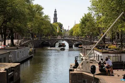 a river with a bridge and a boat on it at The Bright Loft - City Centre Amsterdam in Amsterdam