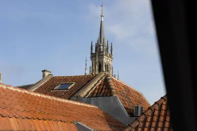 a clock tower on top of a building with orange roofs at Elegant City Apartment in the Heart of Gouda in Gouda