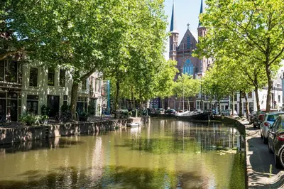 a river in a city with trees and buildings at Elegant City Apartment in the Heart of Gouda in Gouda