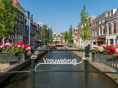 a canal in the middle of a city with flowers at Elegant City Apartment in the Heart of Gouda in Gouda