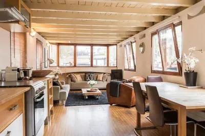 a kitchen and living room with a table and chairs at Luxury Houseboat Prince-William in Amsterdam