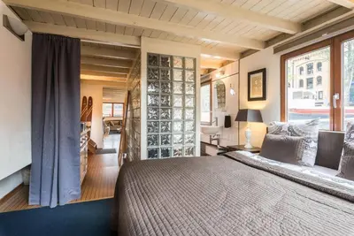 a bedroom with a large bed and a large window at Luxury Houseboat Prince-William in Amsterdam
