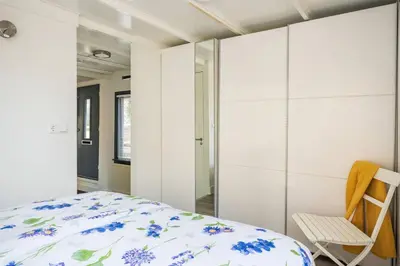a bedroom with a bed and a chair at Luxury Houseboat-Apartment Lady Jane in Amsterdam