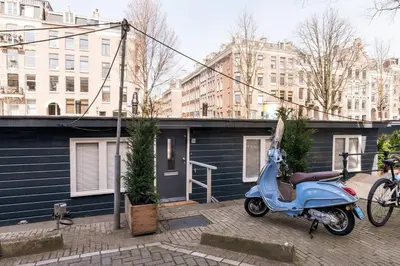 a blue scooter parked in front of a building at Luxury Houseboat-Apartment Lady Jane in Amsterdam