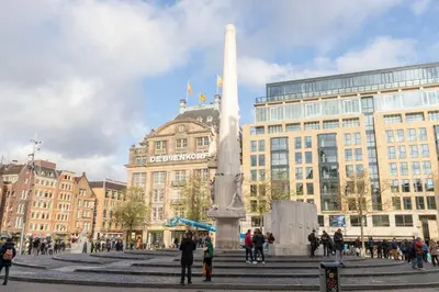 a group of people standing around a monument in front of a building at Luxury Houseboat-Apartment Lady Jane in Amsterdam