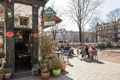 a group of people sitting at tables outside a restaurant at Luxury Houseboat-Apartment Lady Jane in Amsterdam