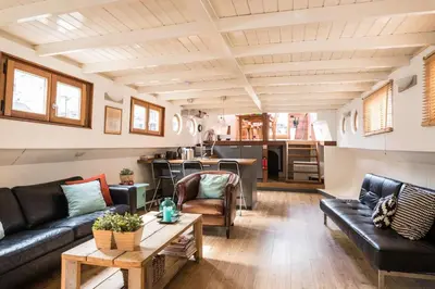 a living room with a couch and a table at Luxury large Houseboat AZARA in Amsterdam