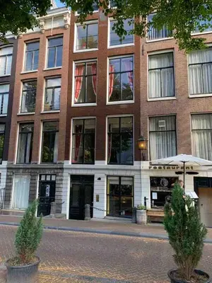 a large brick building with windows on a street at Canal view house - 17th century town house in Amsterdam