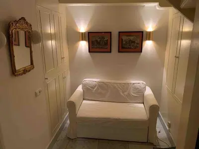 a white couch in a hallway with a mirror at Canal view house - 17th century town house in Amsterdam