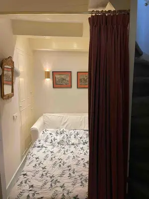 a bedroom with a bed with a curtain next to it at Canal view house - 17th century town house in Amsterdam