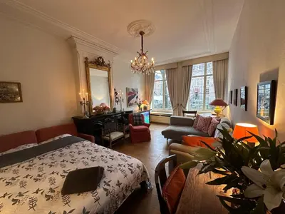 a bedroom with a bed and a living room at Canal view house - 17th century town house in Amsterdam