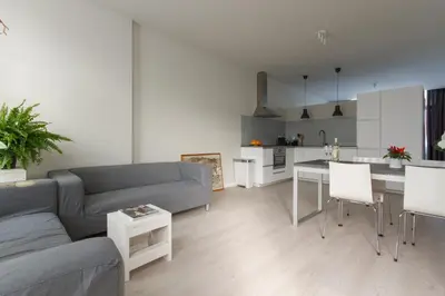 a living room with a couch and a table and a kitchen at Savina oase nabij centrum, zee en station in Zandvoort