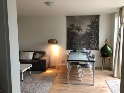 a living room with a table and a couch at Savina oase nabij centrum, zee en station in Zandvoort