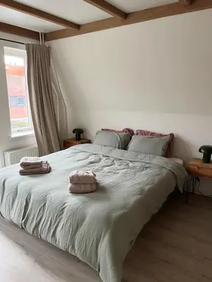 a bedroom with a large bed with two towels on it at Characteristic Dutch home in historic center Gouda in Gouda