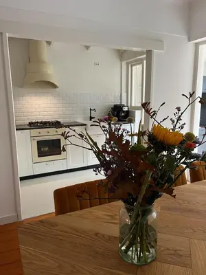 a vase of flowers on a table in a kitchen at Characteristic Dutch home in historic center Gouda in Gouda