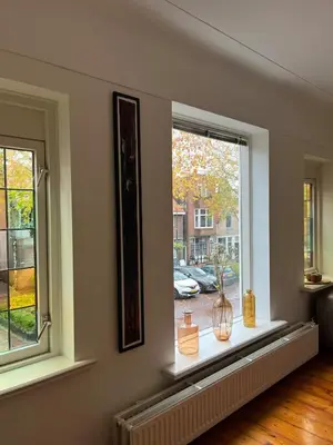 a room with two windows with vases on a window sill at Characteristic Dutch home in historic center Gouda in Gouda