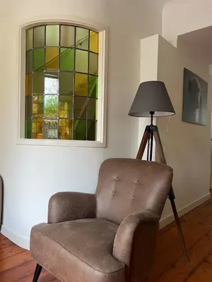 a chair and a lamp in a room with a window at Characteristic Dutch home in historic center Gouda in Gouda