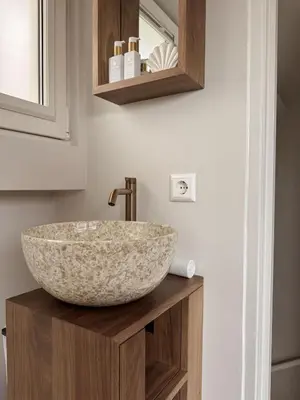 a bathroom with a bowl sink on a wooden counter at C Studio Katwijk in Katwijk aan Zee