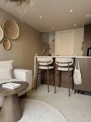 a kitchen with two bar stools and a table at C Studio Katwijk in Katwijk aan Zee