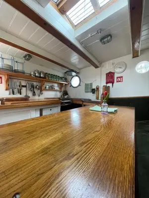 a kitchen with a wooden table in a room at The Vega 1909 - Historic Wooden Ship in Amsterdam