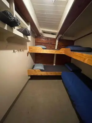 a room with two bunk beds in a room at The Vega 1909 - Historic Wooden Ship in Amsterdam