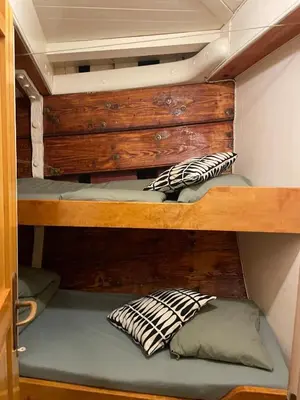 a bunk bed with two pillows on the bottom bunk at The Vega 1909 - Historic Wooden Ship in Amsterdam