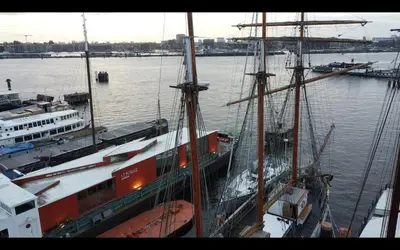 a large boat is docked in the water at The Vega 1909 - Historic Wooden Ship in Amsterdam