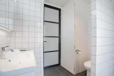 a white bathroom with a sink and a toilet at Charming Apartment with Roof Terrace in Amsterdam