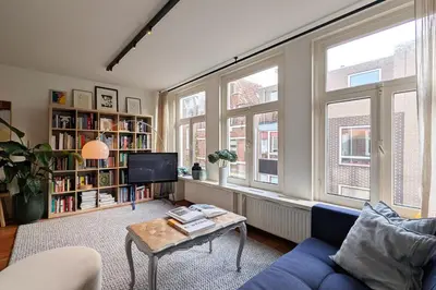 a living room with a blue couch and a table at Charming Apartment with Roof Terrace in Amsterdam