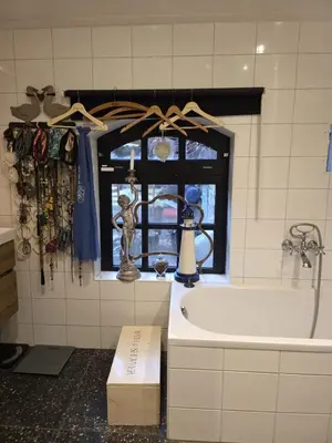 a bathroom with a bath tub and a window at Op Vakantie bij Nicole in Putten