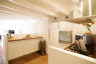 a white kitchen with a sink and a microwave at Canal view luxury apartment in the Jordaan in Amsterdam