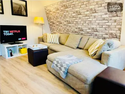 a living room with a couch and a brick wall at Lovely Apartment Wassenaar 6P in Wassenaar