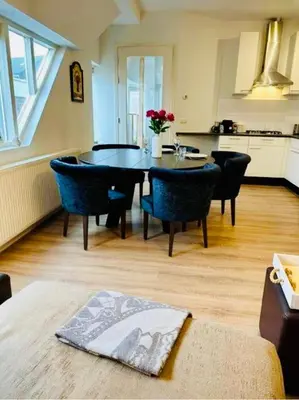 a kitchen and dining room with a table and chairs at Lovely Apartment Wassenaar 6P in Wassenaar