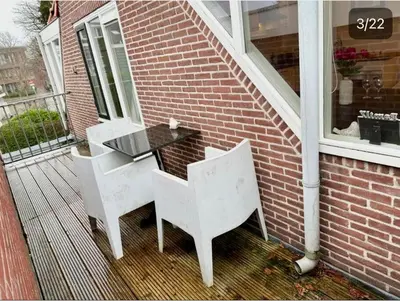 a table and two chairs sitting on a porch at Lovely Apartment Wassenaar 6P in Wassenaar
