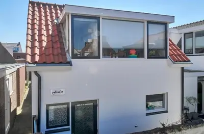 a white house with windows and a roof at Have e nice stay! - Juul 18, free parking in Noordwijk