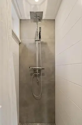 a shower with a shower head in a bathroom at Have e nice stay! - Juul 18, free parking in Noordwijk